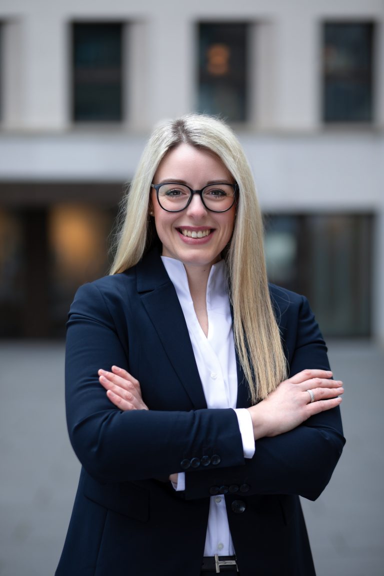 Junge blonde Frau mit Brille und Jacket